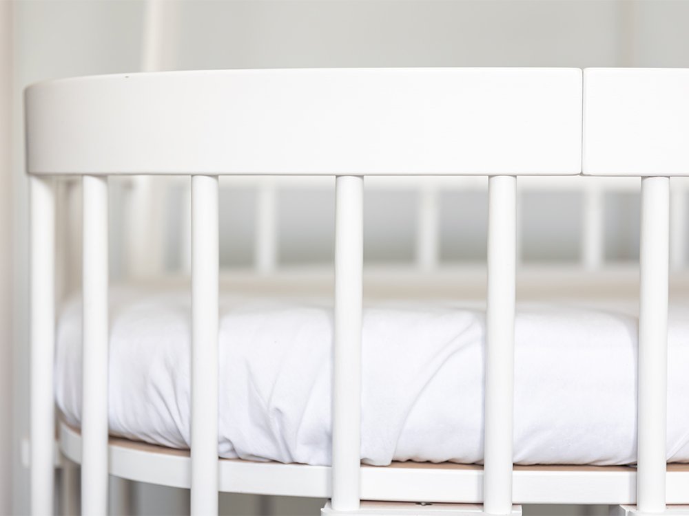 Clean white crib with fitted mattress